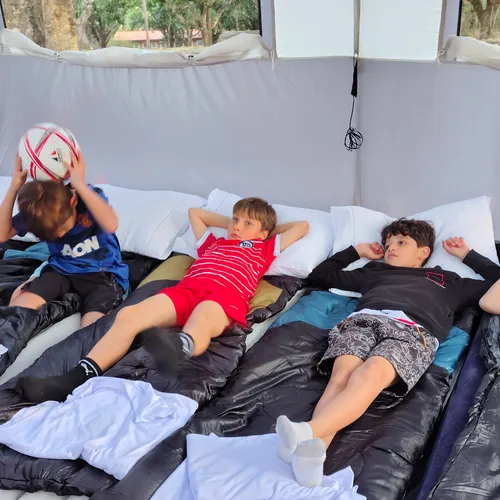 Crianças brincando e descansando dentro da barraca